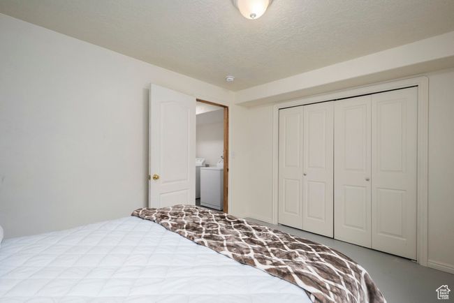 Bedroom featuring a closet, a textured ceiling, and washer / dryer | Image 38