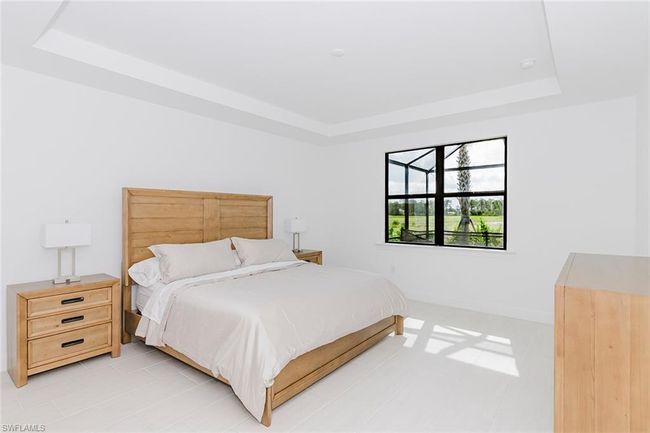 Bedroom with a tray ceiling and baseboards | Image 18