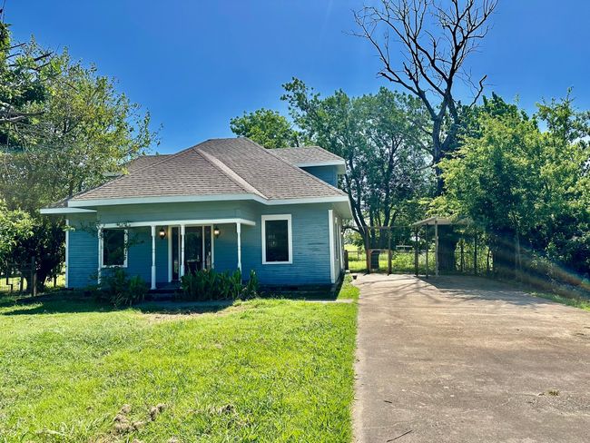 Bungalow-style house featuring a porch, a front yard, a shingled roof, and driveway | Image 23