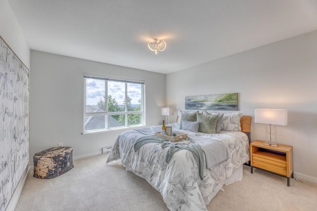 Bedroom with light colored carpet and a baseboard radiator | Image 18