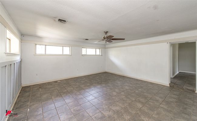 Empty room featuring a textured ceiling, baseboards, ceiling fan, and visible vents | Image 22