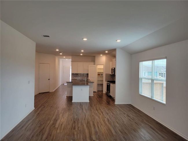 Kitchen featuring stainless steel appliances, dark countertops, dark wood-style floors, backsplash, and open floor plan | Image 14