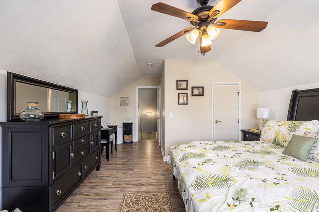 Bedroom featuring dark wood finished floors, vaulted ceiling, baseboards, and ceiling fan | Image 30
