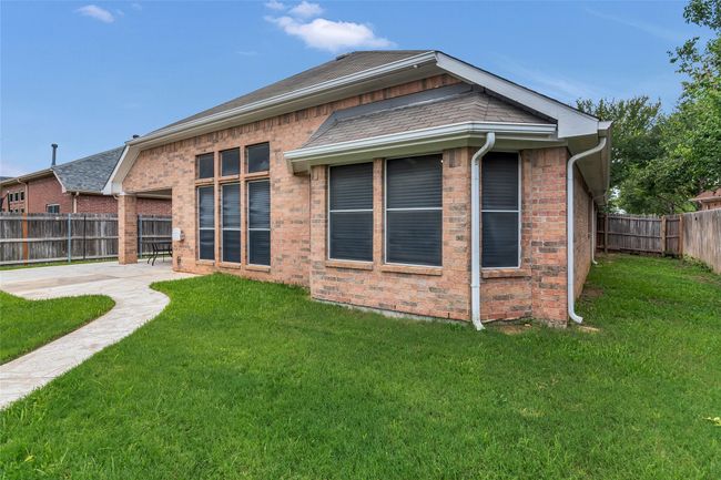 Back of house with a fenced backyard, brick siding, and a patio area | Image 38