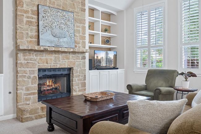 Living area featuring a stone fireplace, plenty of natural light, carpet floors, and baseboards | Image 5