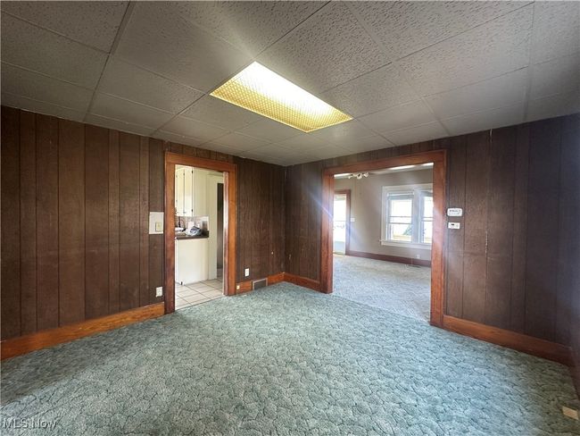 Spare room with wooden walls and light colored carpet | Image 10