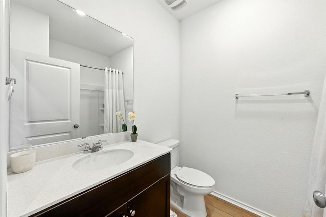 Full bathroom with vanity, wood finished floors, toilet, baseboards, and a shower with shower curtain | Image 19