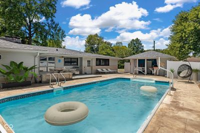 Outdoor in ground heated pool with stamped concrete patio and pool house with bar, storage included. Also 1/2 bath. White vinyl privacy fence. (This image virtually staged.) The pool is not! Pool doesn't have to close after Labor Day! | Image 2