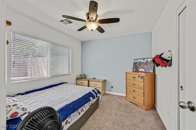 Bedroom with light colored carpet, baseboards, and ceiling fan | Image 20