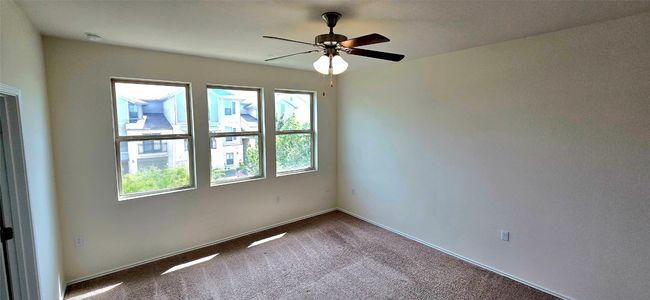 Master bedroom with dark carpet, a ceiling fan, and a smoke detector | Image 16