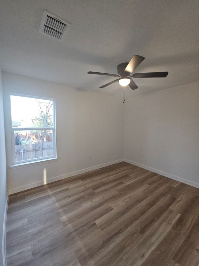 Spare room featuring a ceiling fan, wood finished floors, visible vents, and baseboards | Image 13