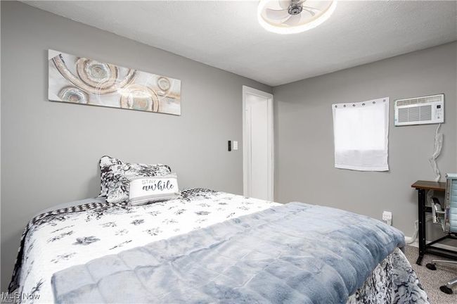 Carpeted bedroom with a wall mounted AC | Image 10