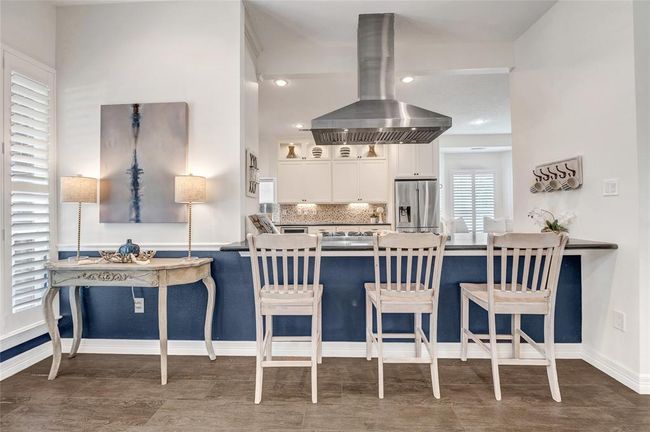 Just on the other side of the kitchen is this well thought out custom bar area open to the living and front of the home. An entertainer's dream! | Image 6