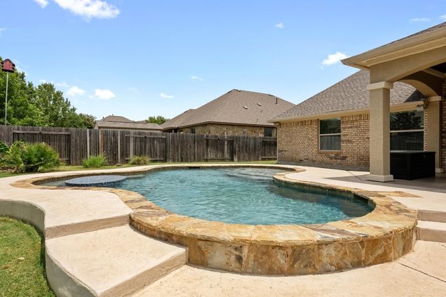 View of pool with a fenced backyard and a patio | Image 31