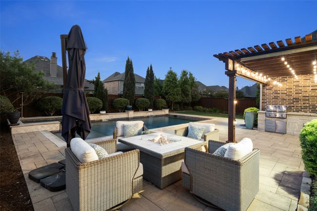 WOW factor is included in this backyard oasis. Pool, spa, water features, tanning ledge, pergola, covered patio space, outdoor build in grill and plenty of entertaining space. | Image 32