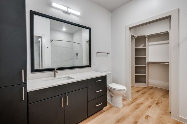 Full bath with a spacious closet, walk in shower, toilet, wood finished floors, and vanity | Image 14