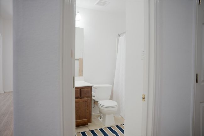 Bathroom with toilet, vanity, and a shower with shower curtain | Image 8