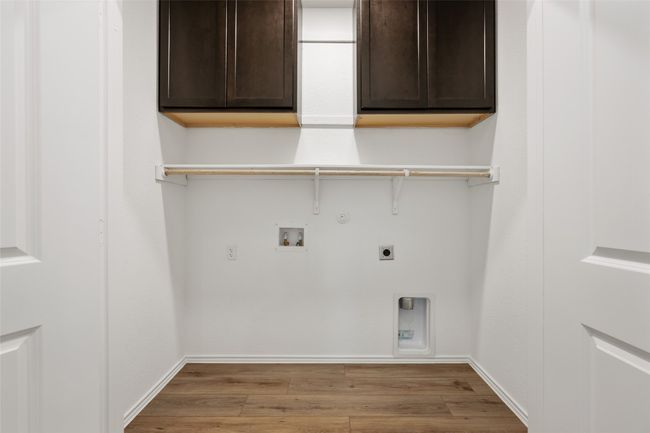 Laundry area featuring cabinet space, hookup for an electric dryer, light wood-style floors, and gas dryer hookup | Image 29