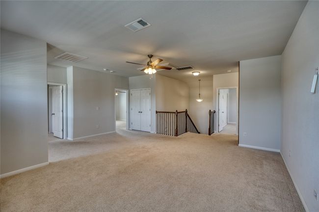 Unfurnished room with visible vents, baseboards, light colored carpet, and ceiling fan | Image 25
