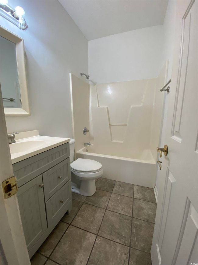 Bathroom with toilet, tile patterned flooring, vanity, and shower / bathtub combination | Image 16