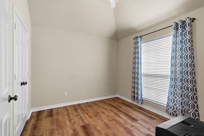 Unfurnished bedroom featuring wood finished floors, lofted ceiling, and a closet | Image 30