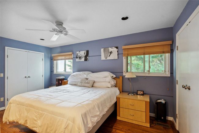 Bedroom with a closet, dark wood-style floors, and a ceiling fan | Image 10