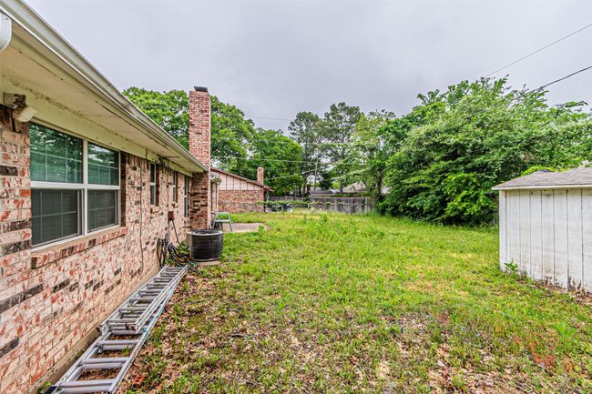 View of yard with fence, an outdoor structure, and cooling unit | Image 35
