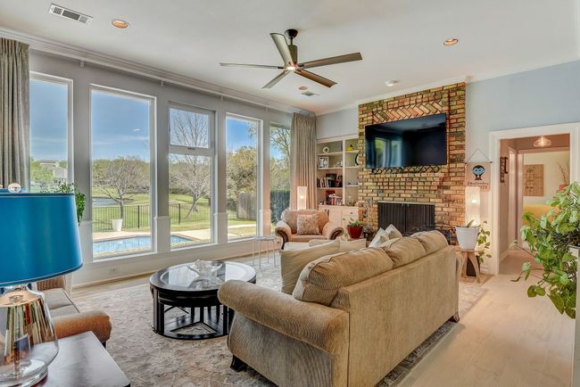 Stunning floor to ceiling custom blue glass windows offer a panoramic view of the backyard | Image 16
