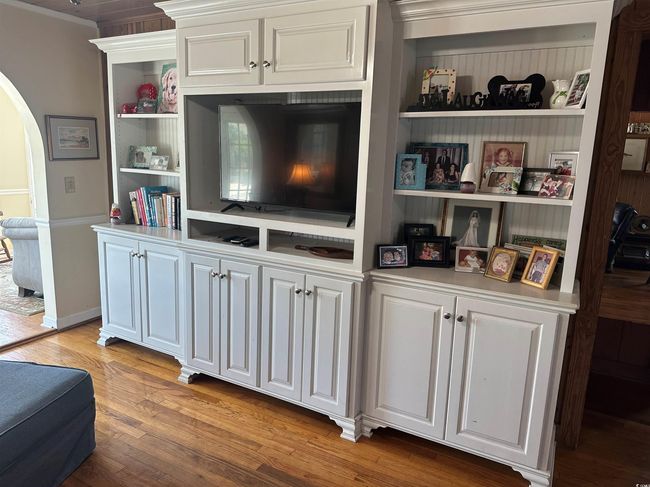 Detailed view of arched walkways, wood finished floors, crown molding, and built in features | Image 6