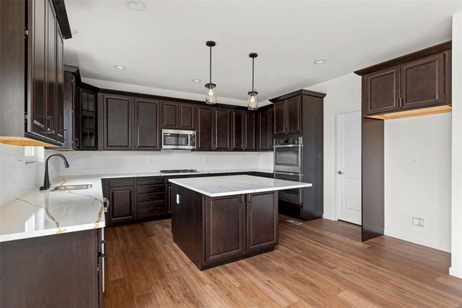 Kitchen featuring sink, a center island, stainless steel appliances, and hardwood / wood-style flooring | Image 23