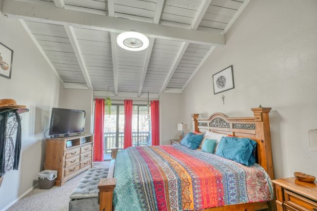 Carpeted bedroom featuring lofted ceiling with beams, access to exterior patio upper unit | Image 22