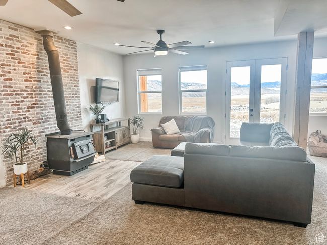 Living room with french doors, ceiling fan, recessed lighting, brick wall, and a wood stove | Image 25