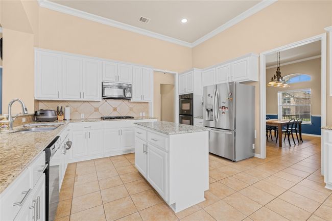 Kitchen featuring light tile floors, a sink, black appliances, and a recessed lighting | Image 24