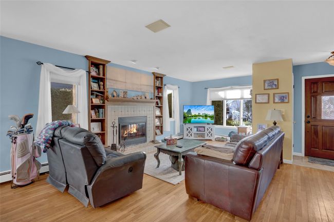 Living room with a tile fireplace and light hardwood / wood-style floors | Image 11