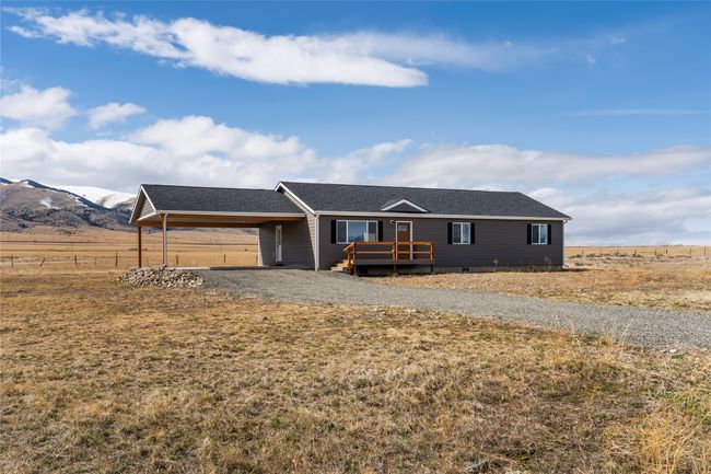 Single story home with fence, driveway, a deck with mountain view, a carport, and a shingled roof | Image 17