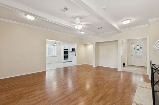 Spacious open living area with engineered hardwood flooring and high quality gas fireplace logs | Image 11