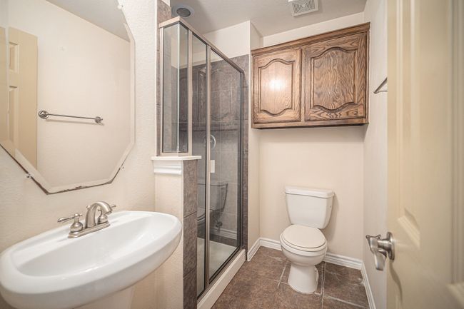 Full bath featuring a sink, toilet, a stall shower, and tile patterned floors | Image 28