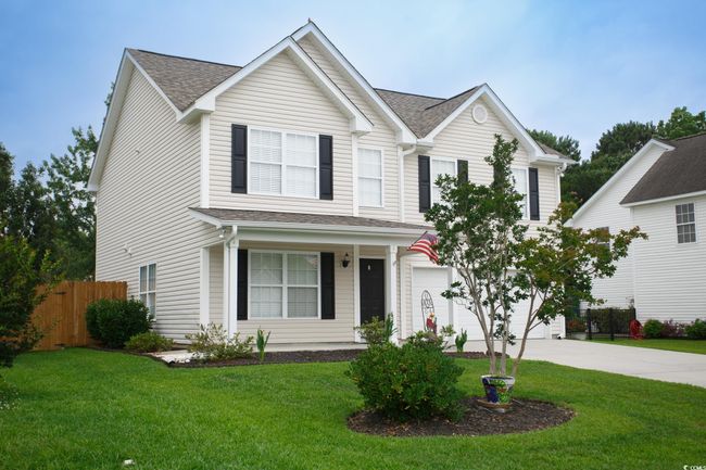Traditional-style home with concrete driveway, a porch, an attached garage, and roof with shingles | Image 32