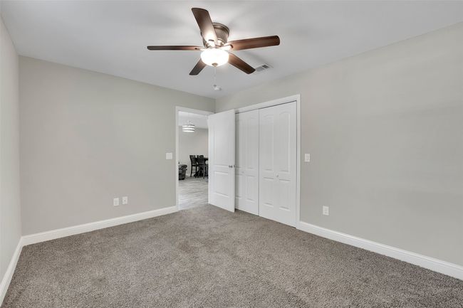 Unfurnished bedroom with visible vents, baseboards, a closet, a ceiling fan, and carpet | Image 28