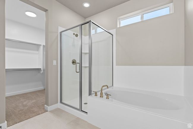 Full bath with a shower stall, a bath, a spacious closet, tile patterned floors, and baseboards | Image 16