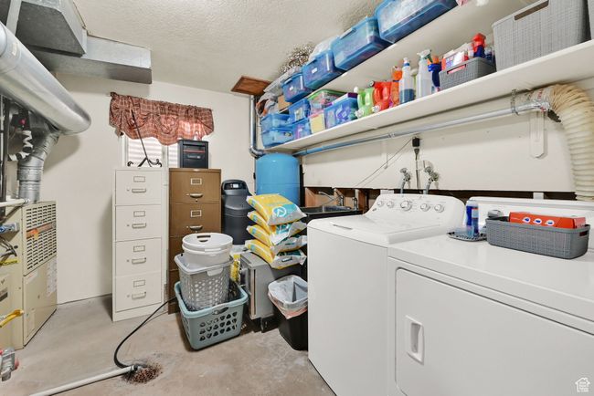 Laundry room with a textured ceiling and washing machine and dryer | Image 29