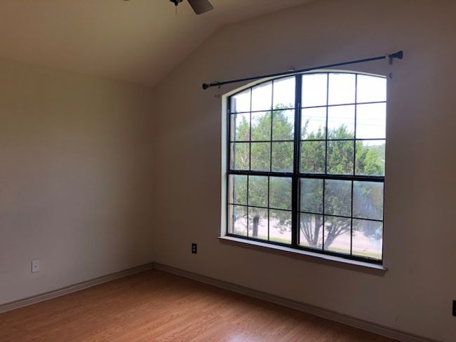 Bedroom with ceiling fan, plenty of natural light, vaulted ceiling, light wood-style floors, and baseboards | Image 10