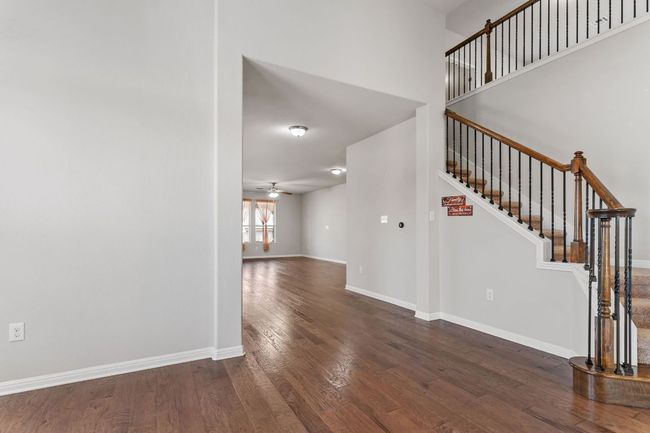 Entryway with baseboards, ceiling fan, stairway, and dark wood finished floors | Image 6