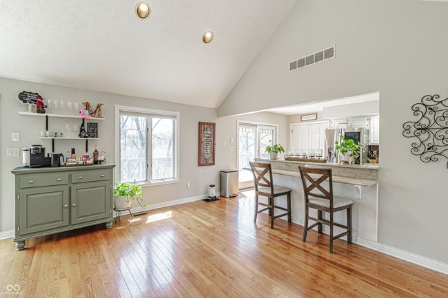 interior space with high vaulted ceiling, baseboards, light wood finished floors, and visible vents | Image 8