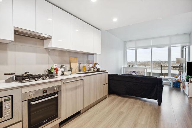 Kitchen with light countertops, a sink, appliances with stainless steel finishes, modern cabinets, and white cabinets | Image 8