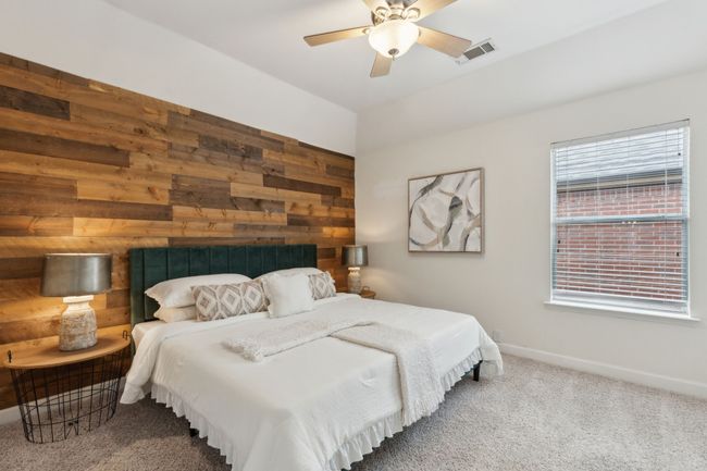 Bedroom featuring wooden walls, carpet floors, baseboards, and a ceiling fan | Image 28