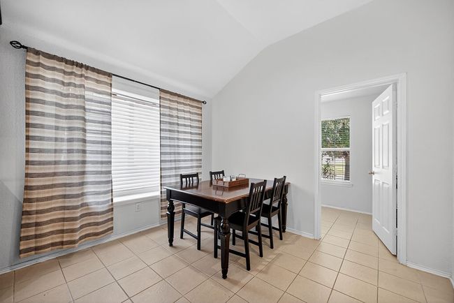 Dining room with lofted ceiling and light tile patterned floors | Image 19