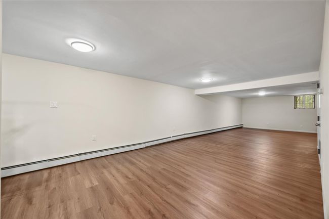 Basement with wood finished floors and a baseboard radiator | Image 37