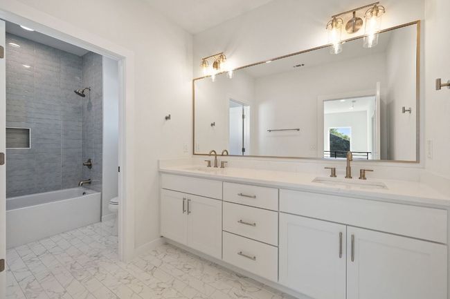 Bathroom featuring marble finish floor, a sink, toilet, and double vanity | Image 23