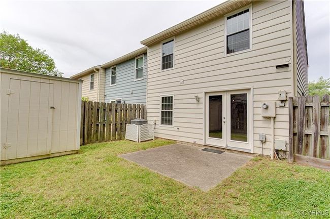Rear view of house featuring french doors, a shed, a fenced backyard, and a patio area | Image 15